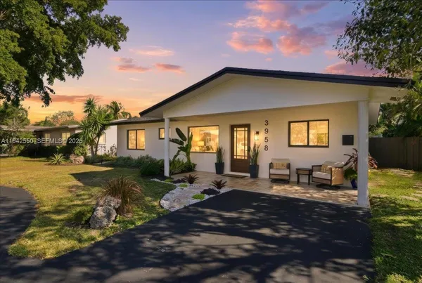a view of a house with backyard and sitting area