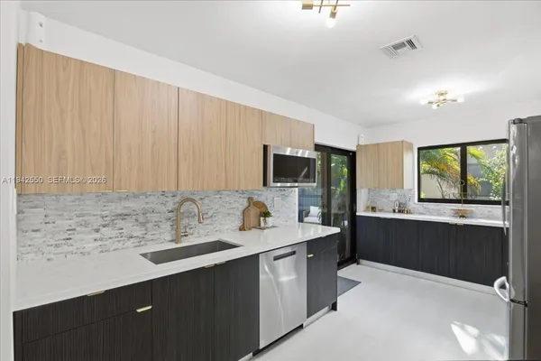 a kitchen with stainless steel appliances a sink stove and refrigerator