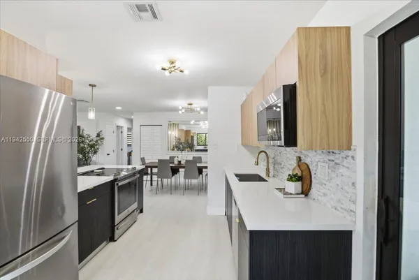 a kitchen with stainless steel appliances granite countertop a sink stove and refrigerator