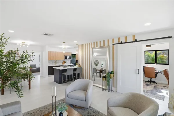 a living room with furniture and view of kitchen