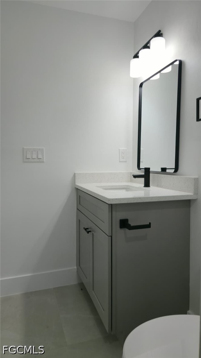 4429 26th Street Southwest Lehigh Acres, FL 33973 - Photo 12 of 16 a bathroom with a granite countertop toilet sink and mirror