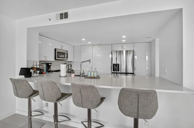 a kitchen with stainless steel appliances a stove microwave and sink