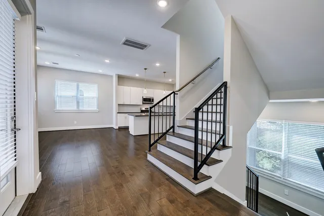 a kitchen with granite countertop white cabinets and stainless steel appliances