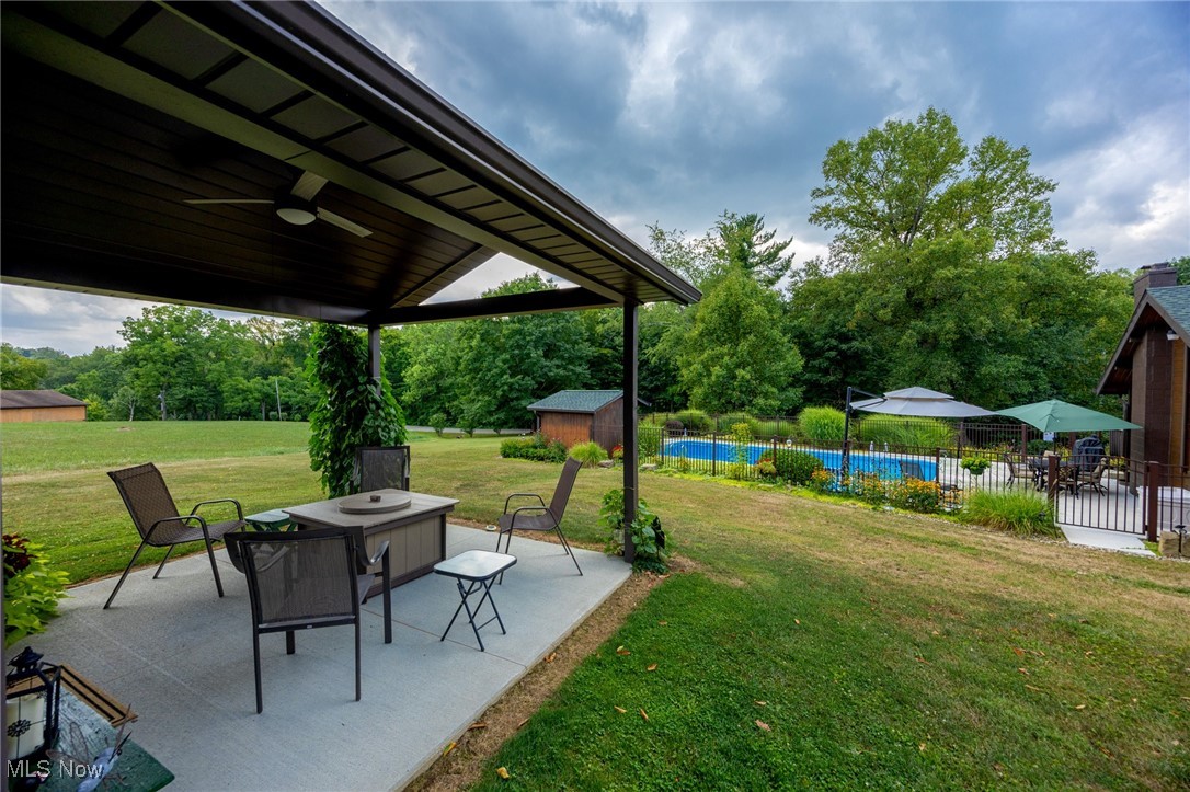 55901 Deep Run Road Martins Ferry, OH 43935 - Photo 6 of 50 View of yard with a patio, ceiling fan, a storage unit, an outbuilding, and view of wooded area