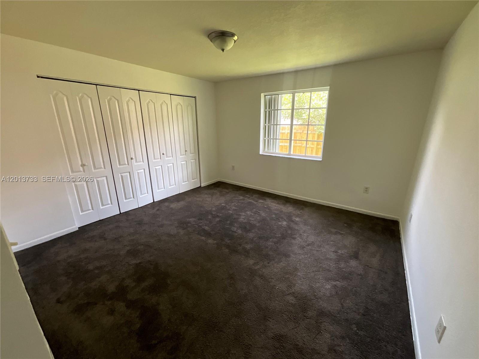 209 Northeast 141st Street, Unit 4 Miami, FL 33161 - Photo 5 of 13 an empty room with windows