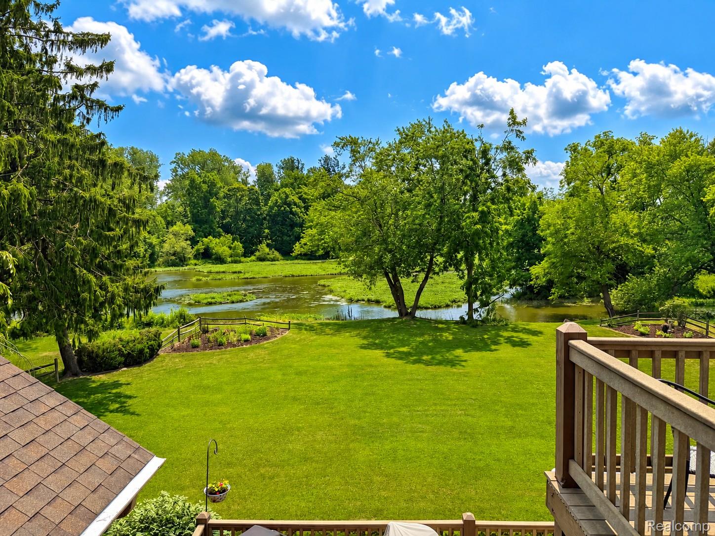 2495 North Custer Road Monroe, MI 48162 - Photo 26 of 44 Expansive green lawn extending to a natural body of water with abundant surrounding foliage