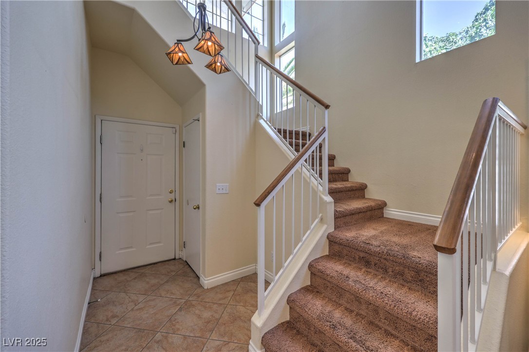 8325 Alta Drive Las Vegas, NV 89145 - Photo 16 of 31 Entrance foyer featuring light tile patterned floors and stairs