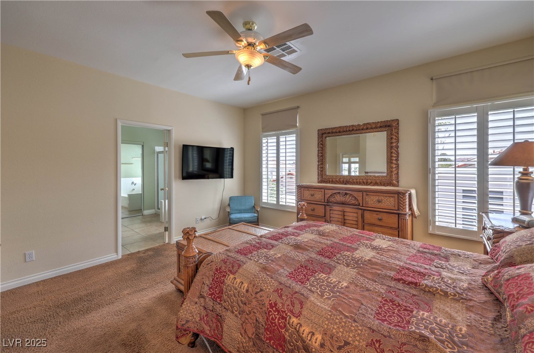 8325 Alta Drive Las Vegas, NV 89145 - Photo 18 of 31 Bedroom with carpet floors, a ceiling fan, and connected bathroom