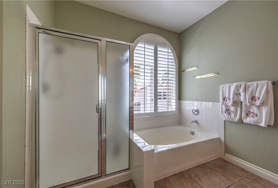 8325 Alta Drive Las Vegas, NV 89145 - Photo 20 of 31 Bathroom with a textured wall, a stall shower, a garden tub, and light tile patterned floors