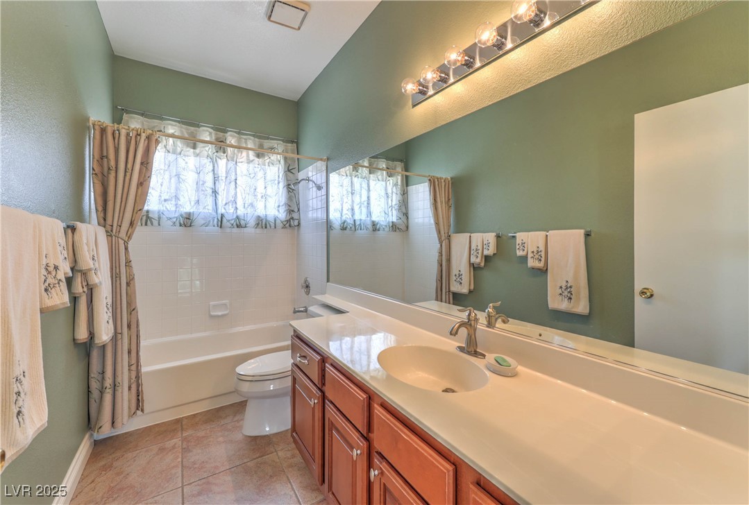 8325 Alta Drive Las Vegas, NV 89145 - Photo 22 of 31 Upstairs Bathroom featuring shower / bath combo with shower curtain, vanity, and light tile patterned flooring