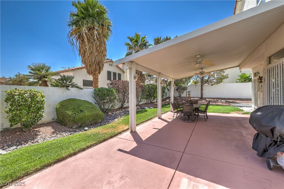 8325 Alta Drive Las Vegas, NV 89145 - Photo 25 of 31 Fenced backyard with ceiling fan, a covered patio, outdoor dining area, and grilling area