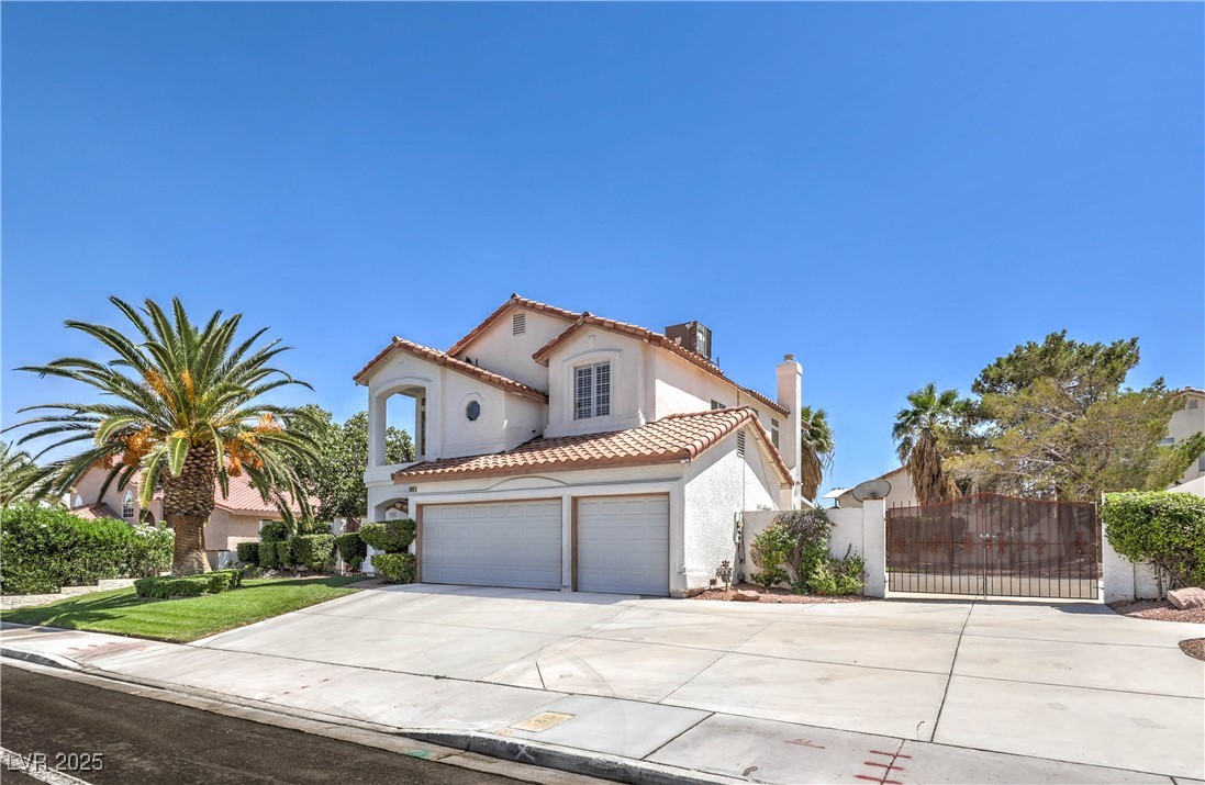 8325 Alta Drive Las Vegas, NV 89145 - Photo 3 of 31 Mediterranean / spanish-style house featuring a gate, driveway, a tiled roof, stucco siding, and a chimney