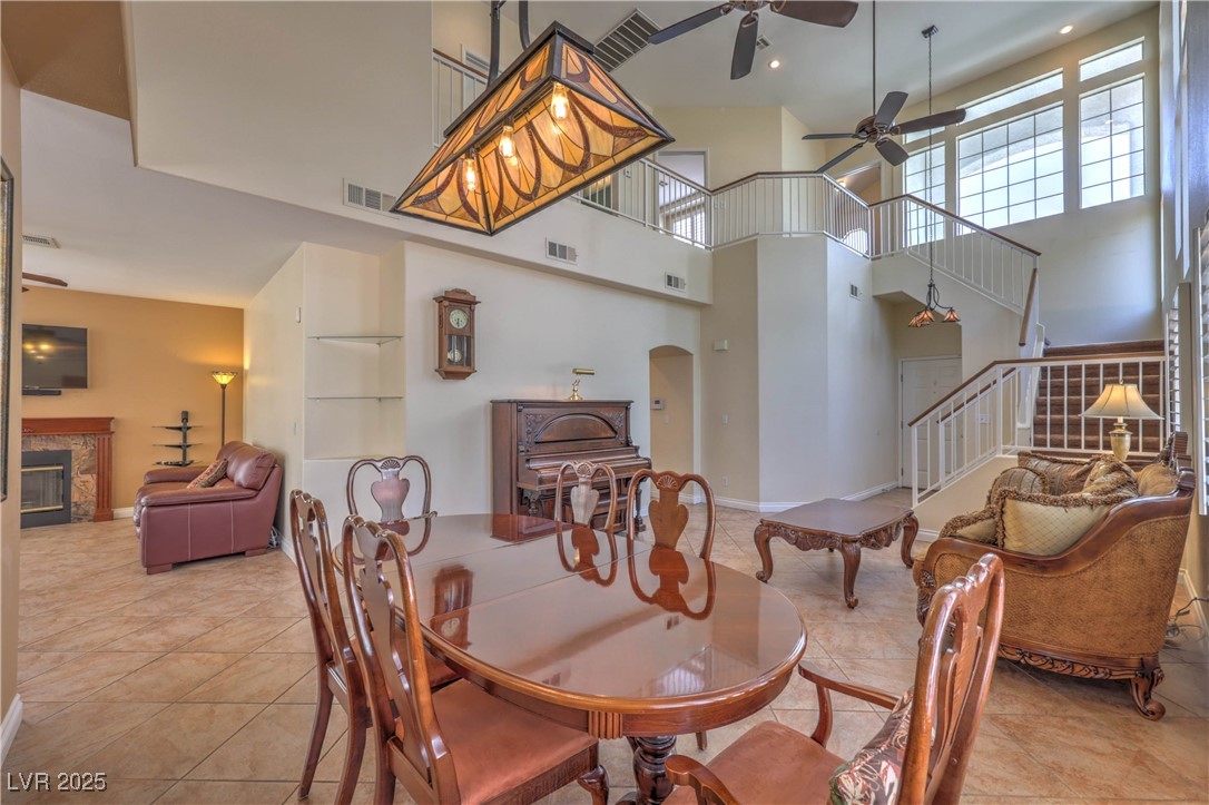 8325 Alta Drive Las Vegas, NV 89145 - Photo 8 of 31 Dining room with a ceiling fan, a towering ceiling, and light tile patterned floors