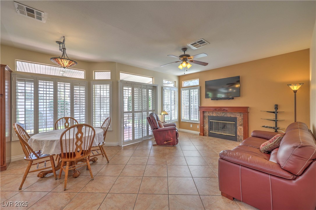 8325 Alta Drive Las Vegas, NV 89145 - Photo 9 of 31 Living room featuring a premium fireplace, light tile patterned flooring, and ceiling fan