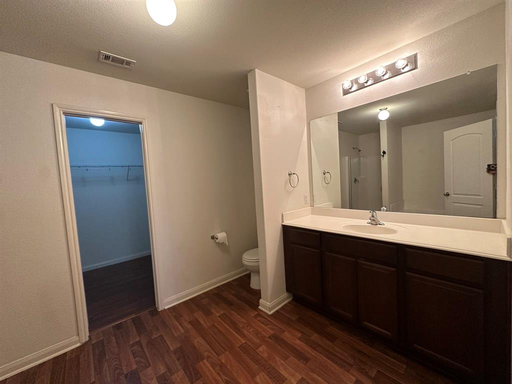 1818 Clegg Street Howe, TX 75459 - Photo 16 of 34 Bathroom featuring a single vanity with dark wood-finish cabinetry, a large frameless mirror, and a modern four-light fixture