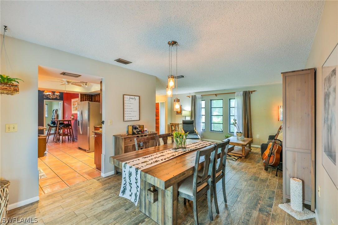 7213 Myrtle Road Fort Myers, FL 33967 - Photo 14 of 35 a dining room with furniture a chandelier and wooden floor