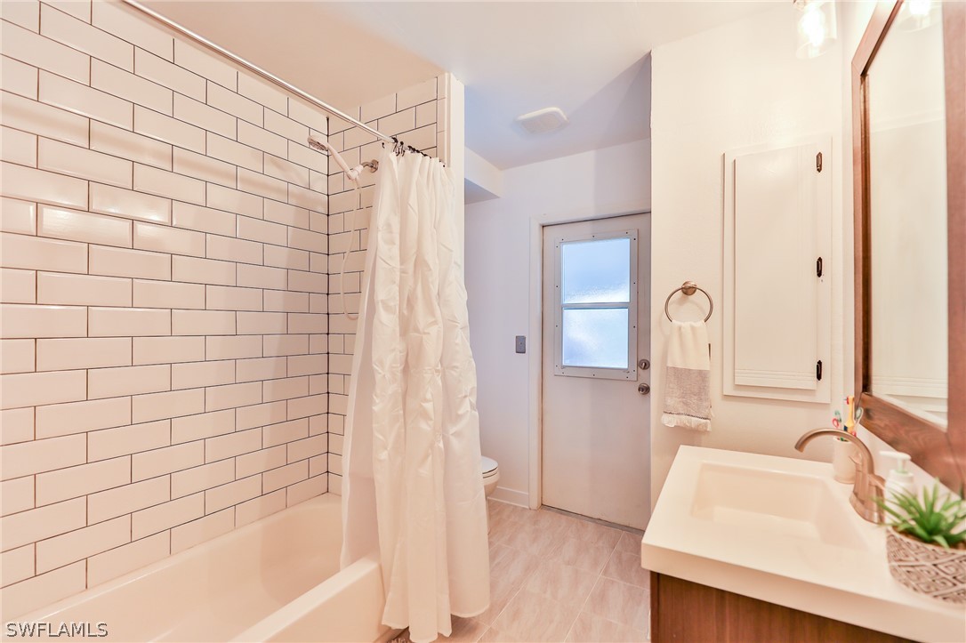 7213 Myrtle Road Fort Myers, FL 33967 - Photo 15 of 35 a bathroom with a bathtub a sink and a shower