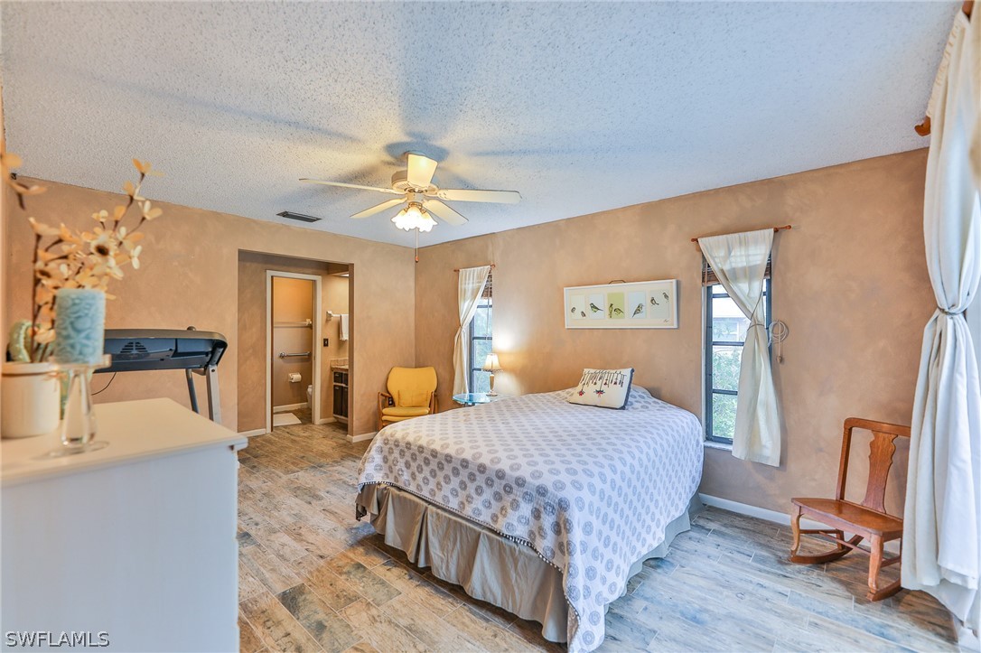 7213 Myrtle Road Fort Myers, FL 33967 - Photo 17 of 35 a bedroom with a bed flat screen tv and couches