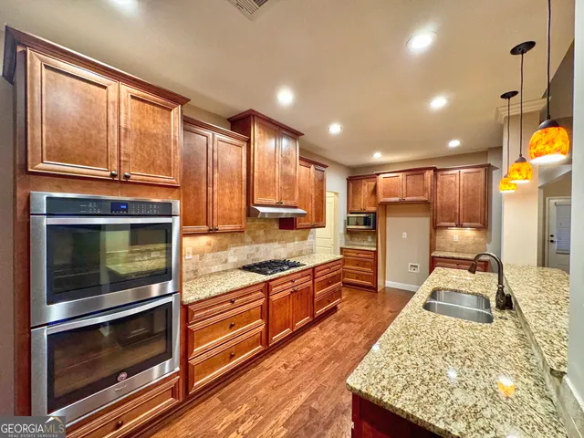 a kitchen with stainless steel appliances kitchen island granite countertop a stove and cabinets