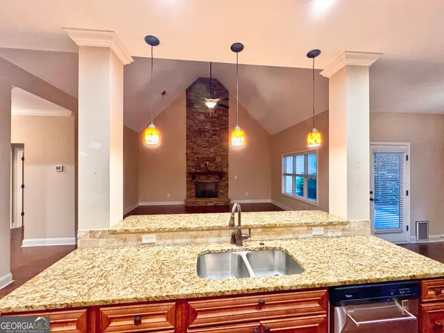 a view of a kitchen with granite countertop a sink and a counter