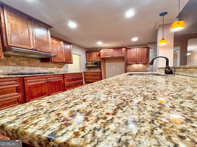a large kitchen with kitchen island granite countertop a sink and cabinets