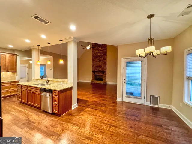 a large kitchen with stainless steel appliances granite countertop a stove and cabinets with wooden floor