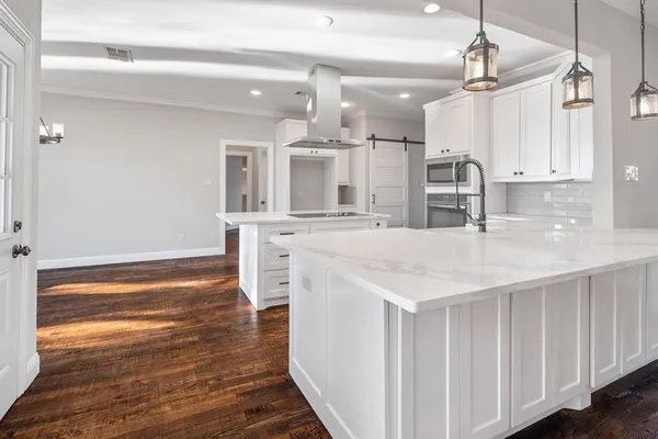 a kitchen with stainless steel appliances kitchen island granite countertop a refrigerator and a sink