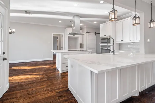 a kitchen with stainless steel appliances kitchen island granite countertop a refrigerator and a sink