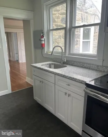 a kitchen with granite countertop a stove and a sink