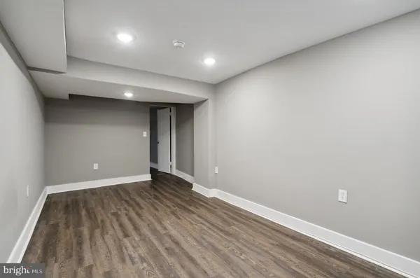 an empty room with wooden floor and natural light