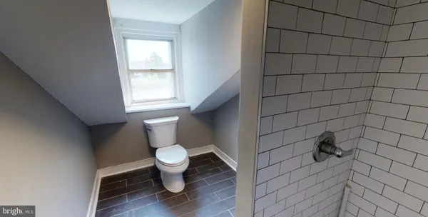 a bathroom with a toilet and a shower