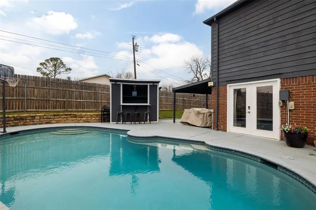 a view of a house with a swimming pool and sitting area