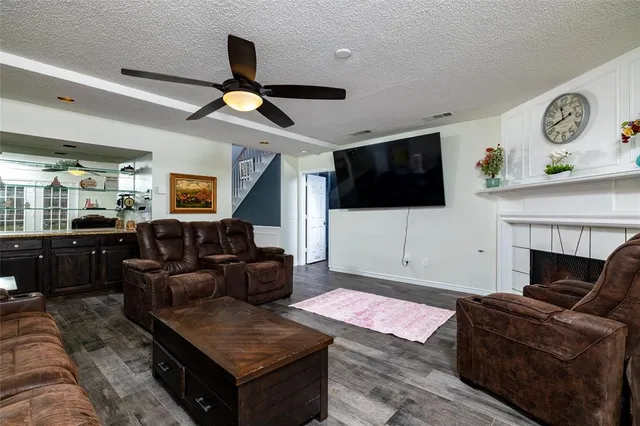 a living room with furniture a flat screen tv and a fireplace
