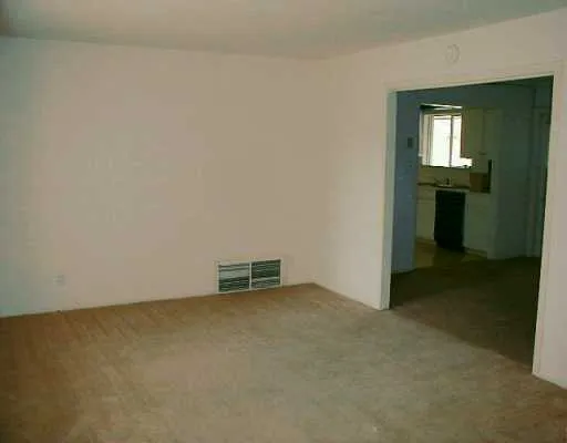 an empty room with a bench and a sink