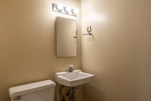 a bathroom with a sink a toilet and mirror