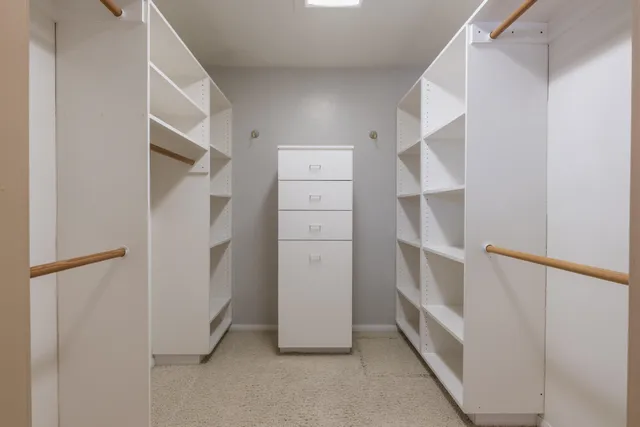 a view of walk in closet with empty racks