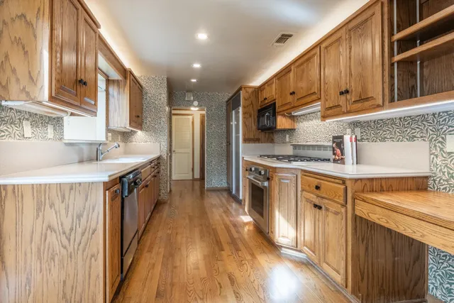 a kitchen with stainless steel appliances granite countertop a sink stove and refrigerator