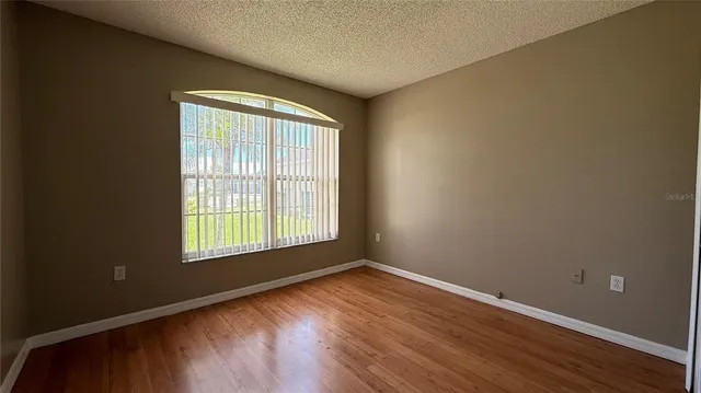 an empty room with wooden floor and entrance