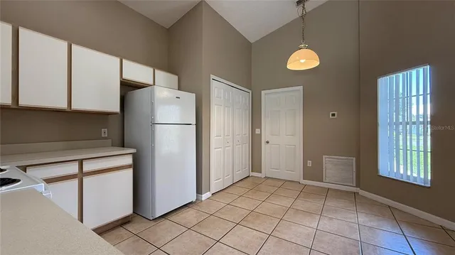 a view of a kitchen with a refrigerator cabinets and a window