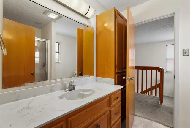 a bathroom with a granite countertop sink and a mirror