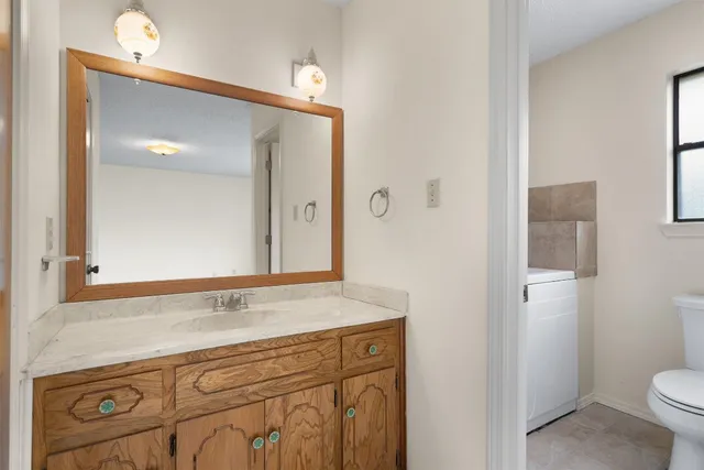 a bathroom with a sink and mirror with toilet