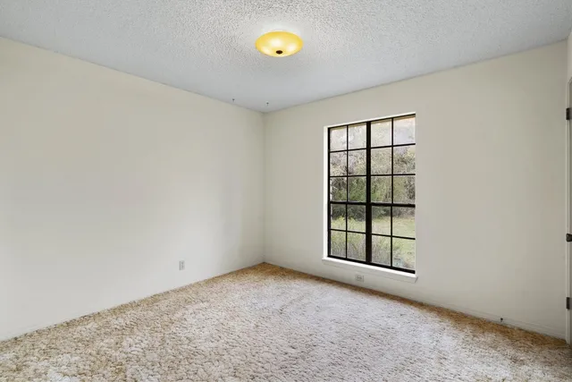 an empty room with windows and cabinet