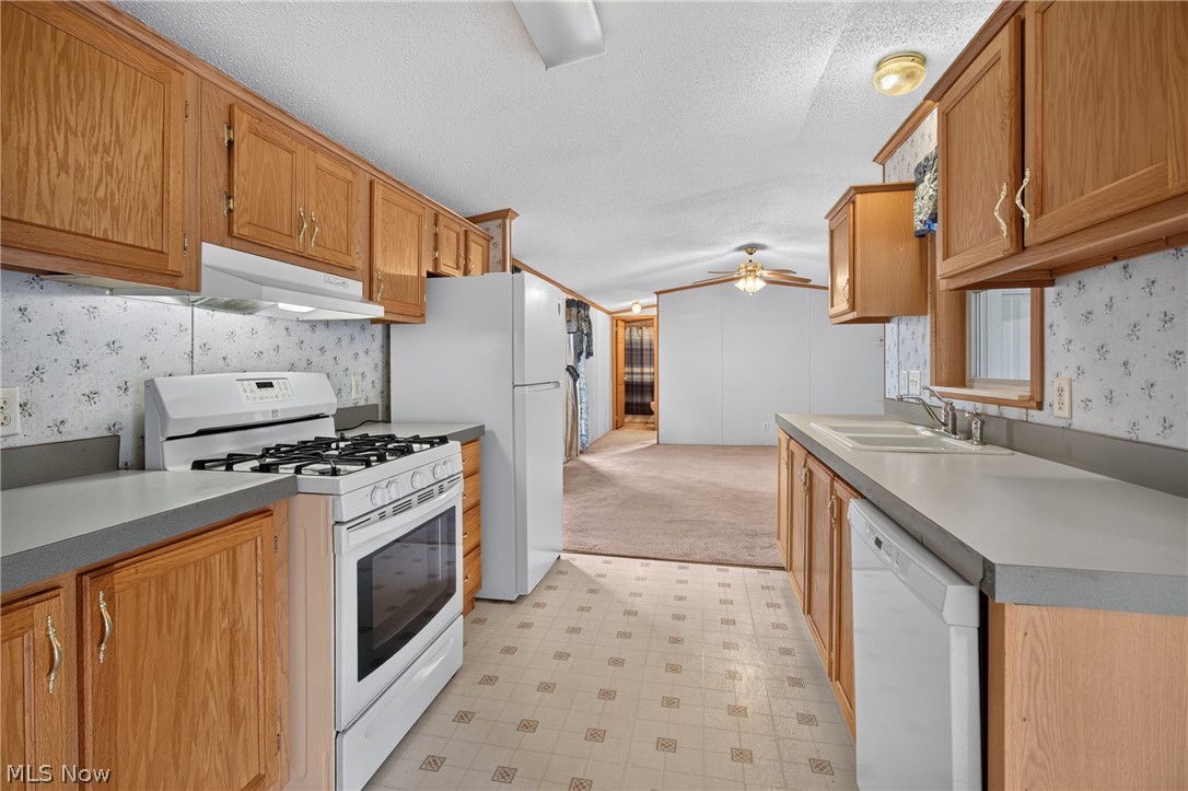 35157 Center Ridge Road, Unit 153 North Ridgeville, OH 44039 - Photo 17 of 35 Kitchen featuring wood cabinetry, laminate countertops, a gas range, and patterned flooring