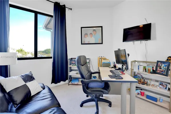 a view of a workspace with furniture and a flat screen tv
