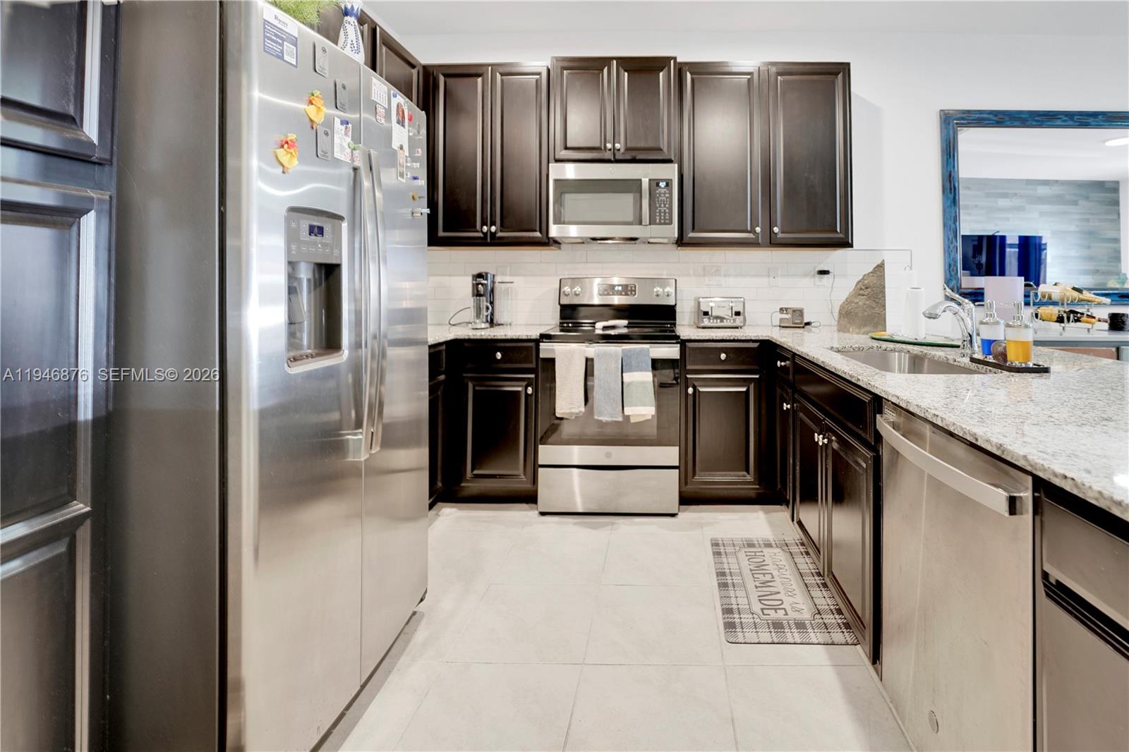 23302 Southwest 110th Avenue Homestead, FL 33032 - Photo 4 of 26 a kitchen with stainless steel appliances granite countertop a refrigerator stove a sink and dishwasher