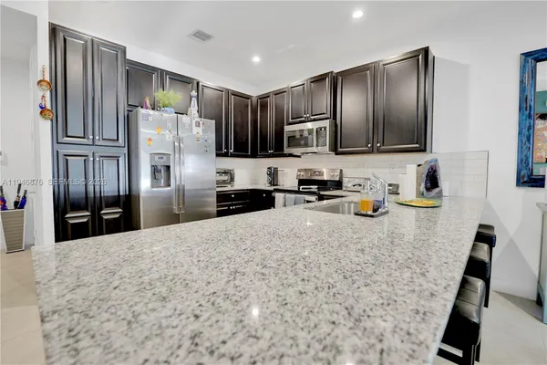 a kitchen with stainless steel appliances wooden cabinets a refrigerator and a sink