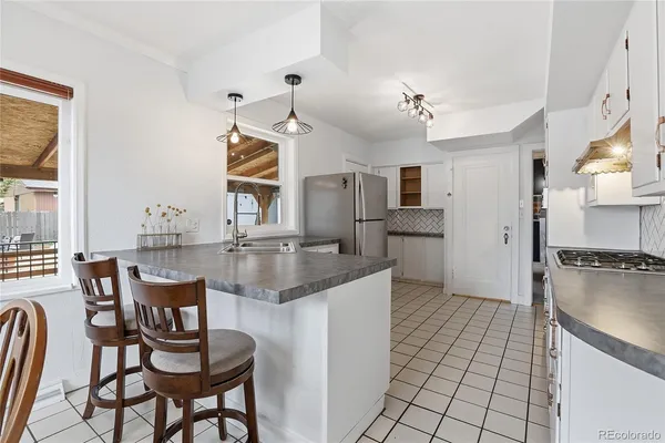 a kitchen with granite countertop cabinets and chairs