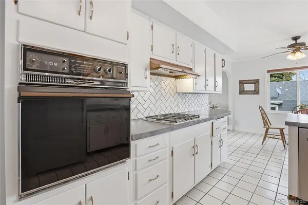 a kitchen with white cabinets and appliances