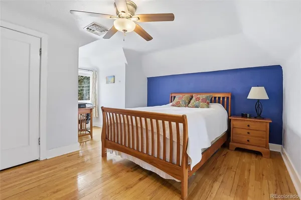 a bedroom with bed and wooden floor