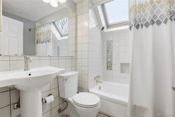 a bedroom with a bed chandelier and a window